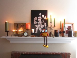 Our Fall (Halloween!) mantel. Not a leaf in sight, but we've got candles; original traditional and bizarre art; an assortment of tools; an old brass key; a petrol lamp; a bronze clock; an antique candelabra and a silly stuffed owl.