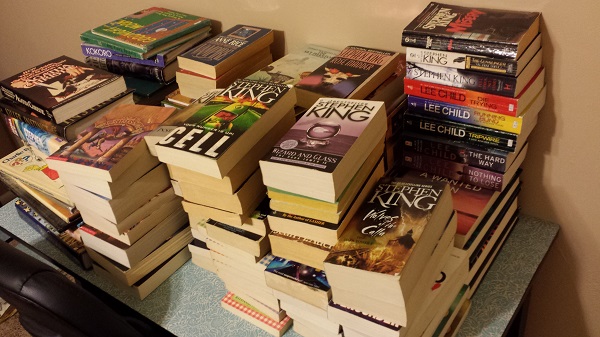 Piles of books on the desk in the guest bedroom.