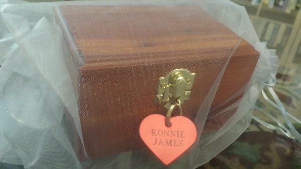 A little padlock hangs beneath the heart name-tag, and there are two keys for it taped to the underside of the urn.