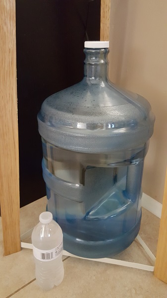 16.9 fl oz of water in the small bottle. 5 gallons of water in the large bottle.